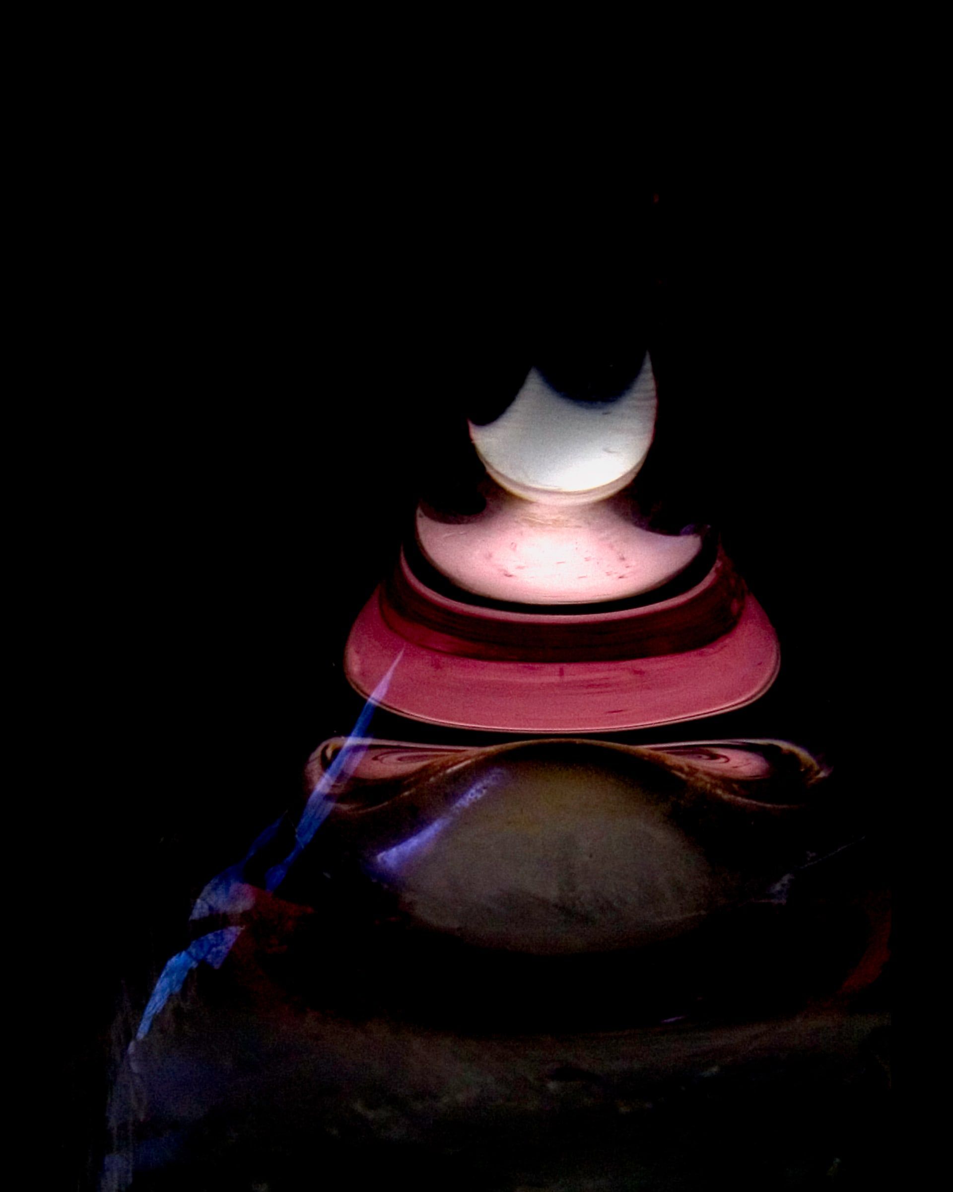 Stacked glowing forms in rose and moon-white rising out of darkness